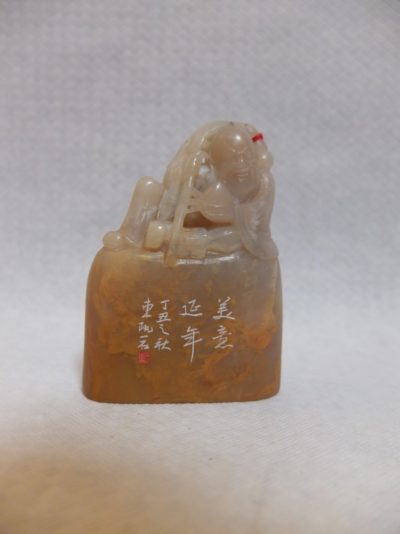 Chinesischer Mann auf Stein mit chinesischen Schriftzeichen verziert.