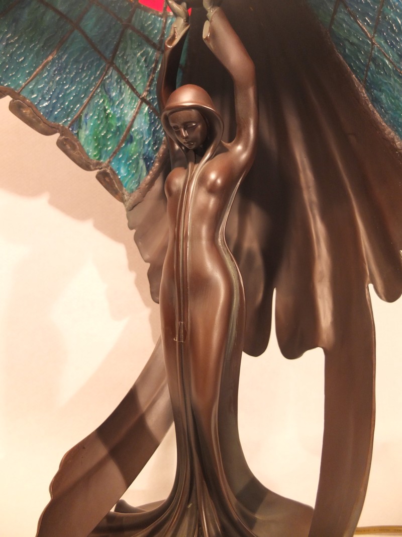 Tiffanylampe mit Bronzefigur Material: Glas/ Metall Motiv: Figur / Engel die Lampe hoch hält Maße: 66 x 43 cm Gewicht: 15 kg